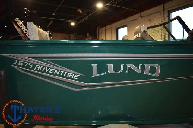 Slide: The Image of 2025 Lund 1675 Adventure Sport boat in showroom, green exterior with branding. - 4