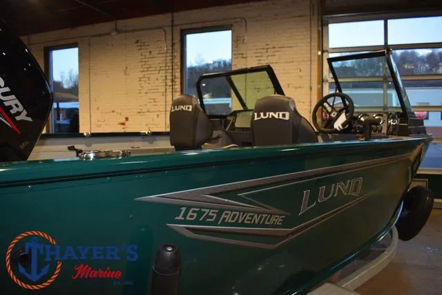 Slide: The Image of 2025 Lund 1675 Adventure Sport boat in showroom, featuring sleek design and branding. - 43