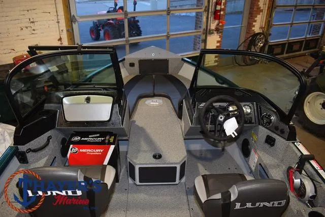 Slide: The Image of 2025 Lund 1675 Adventure Sport boat interior with steering wheel and Mercury controls. - 9