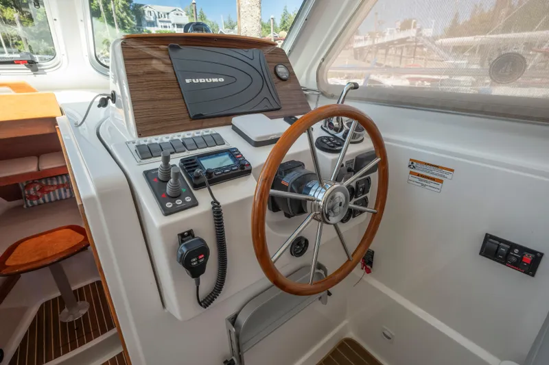 Slide: The Image of 2016 Back Cove 30 boat helm with steering wheel and navigation equipment. - 15