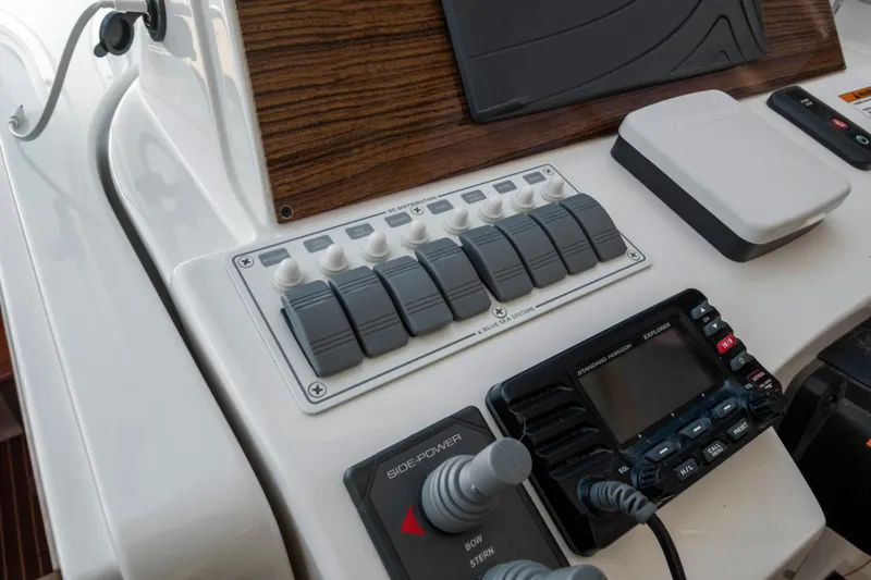 Slide: The Image of Control panel of a 2016 Back Cove 30 boat with switches and navigation equipment. - 16