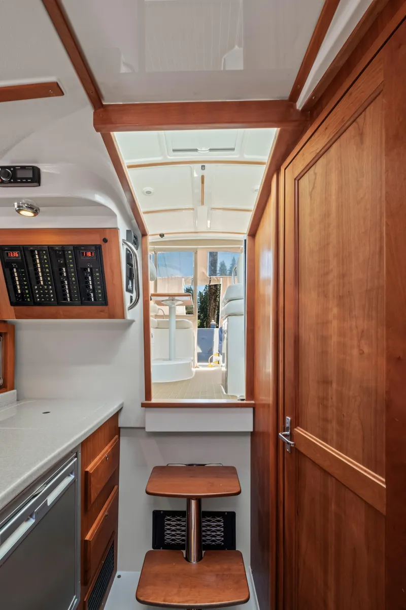 Slide: The Image of 2016 Back Cove 30 yacht interior with wooden cabinetry and compact kitchen area. - 19