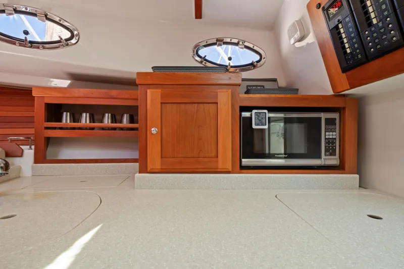 Slide: The Image of 2016 Back Cove 30 yacht interior with microwave and wooden cabinetry. - 22