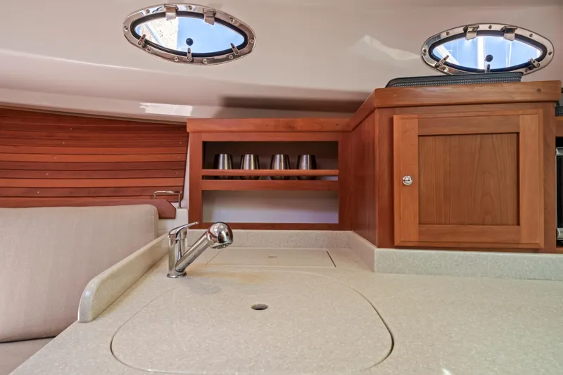 Slide: The Image of 2016 Back Cove 30 yacht interior with wooden cabinetry and portholes. - 23