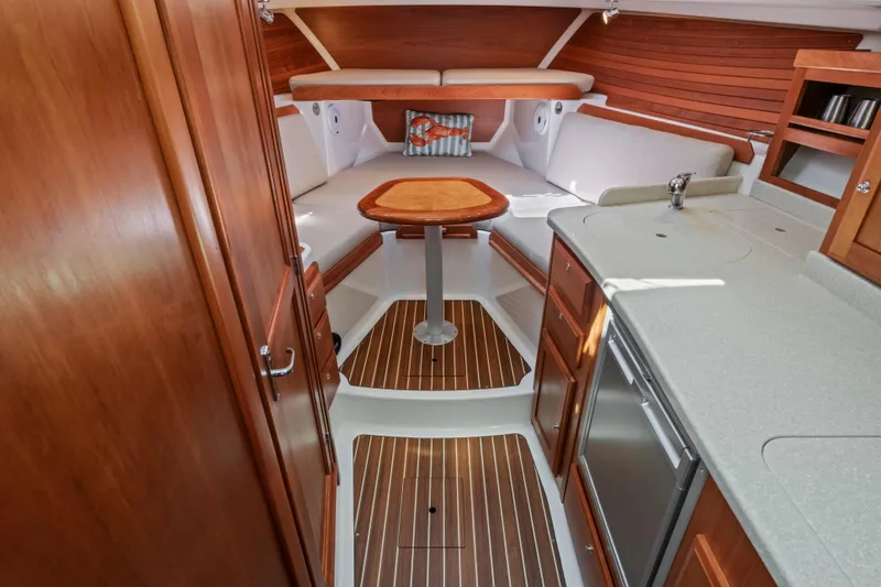 Slide: The Image of Interior of 2016 Back Cove 30 boat with wood accents and compact kitchen area. - 24