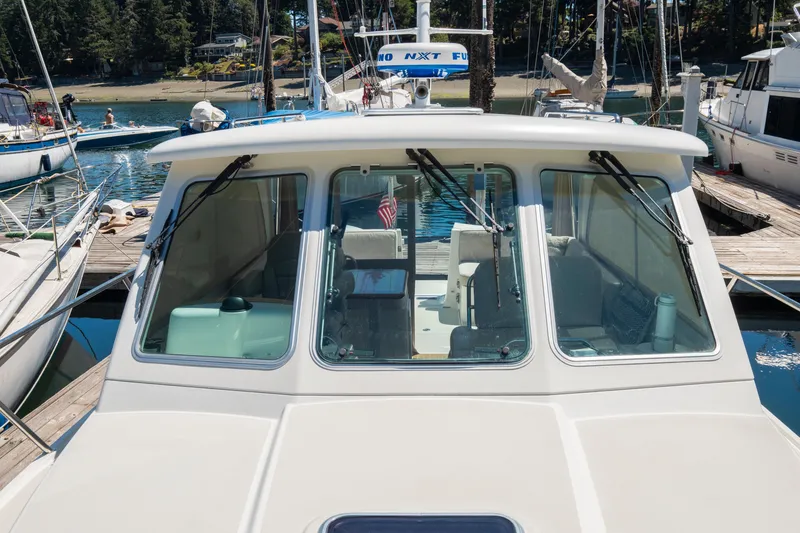 Slide: The Image of 2016 Back Cove 30 boat docked at marina, front view with clear windows. - 35