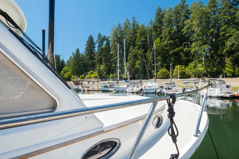 Slide: The Image of 2016 Back Cove 30 boat docked in a serene marina with lush trees. - 36