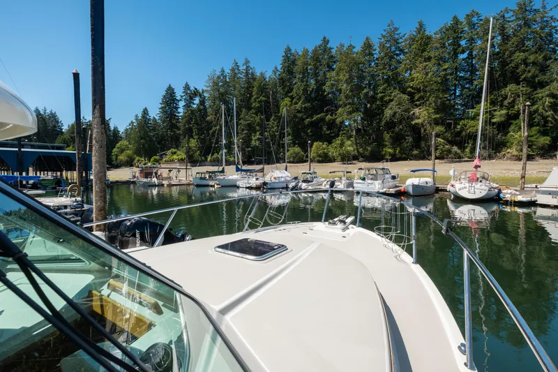 Slide: The Image of 2016 Back Cove 30 boat docked in a scenic marina with lush trees. - 37