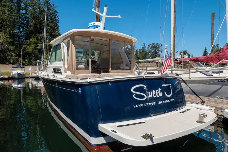 Slide: The Image of 2016 Back Cove 30 boat docked, named "Sweet J," with American flag, Harstine Island, WA. - 40