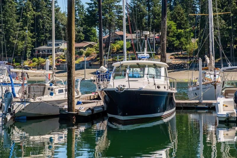 Slide: The Image of 2016 Back Cove 30 boat docked in a serene marina setting. - 42