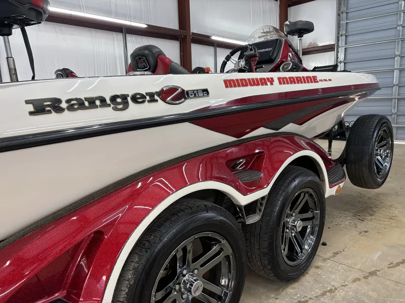Slide: The Image of 2018 Ranger Z518c boat with red and white design in a garage setting. - 11