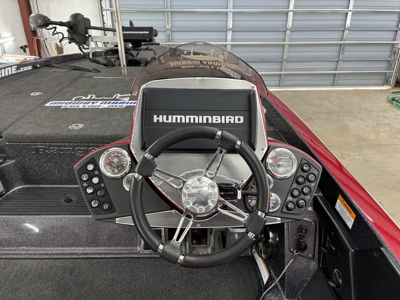 Slide: The Image of 2018 Ranger Z518c boat dashboard with Humminbird display and steering wheel in a garage. - 15