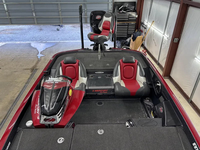 Slide: The Image of 2018 Ranger Z518c bass boat interior with red and black seating in a garage. - 18