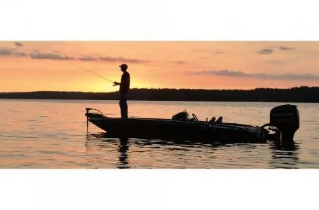 Slide: The Image of Silhouette of a person fishing on a 2018 Ranger Z518c boat at sunset. - 20