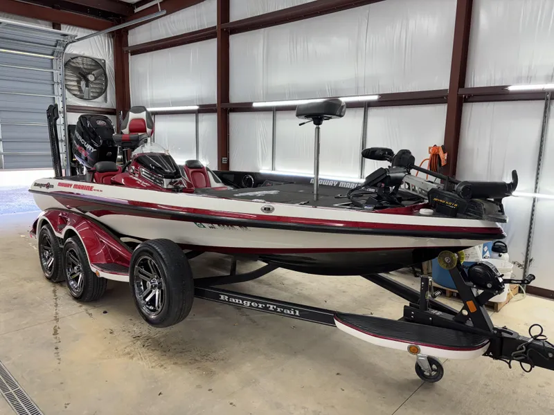 Slide: The Image of 2018 Ranger Z518c bass boat in a garage, featuring a sleek design and trailer. - 32