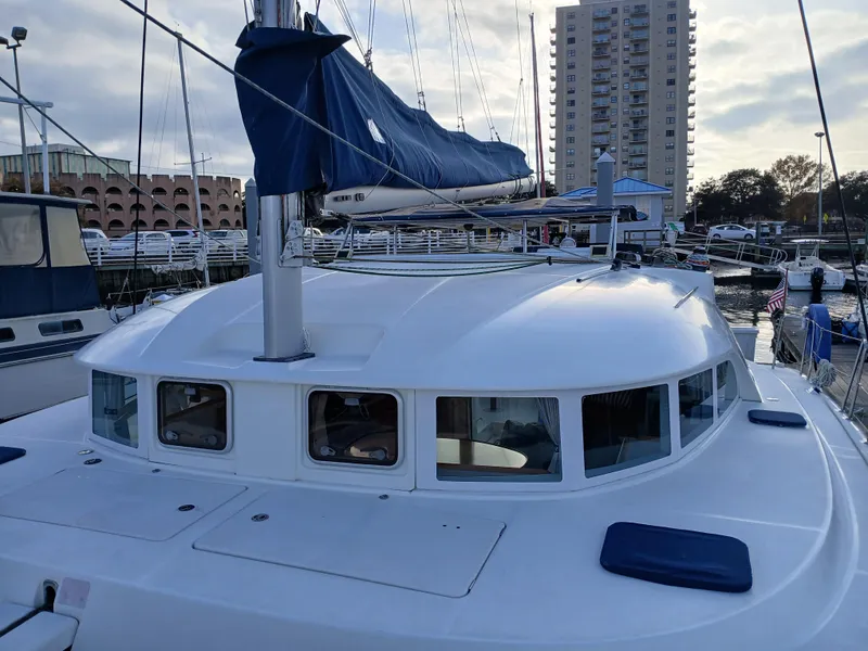 Slide: The Image of 2007 Lagoon 380 S2 catamaran docked at marina with cityscape background. - 12