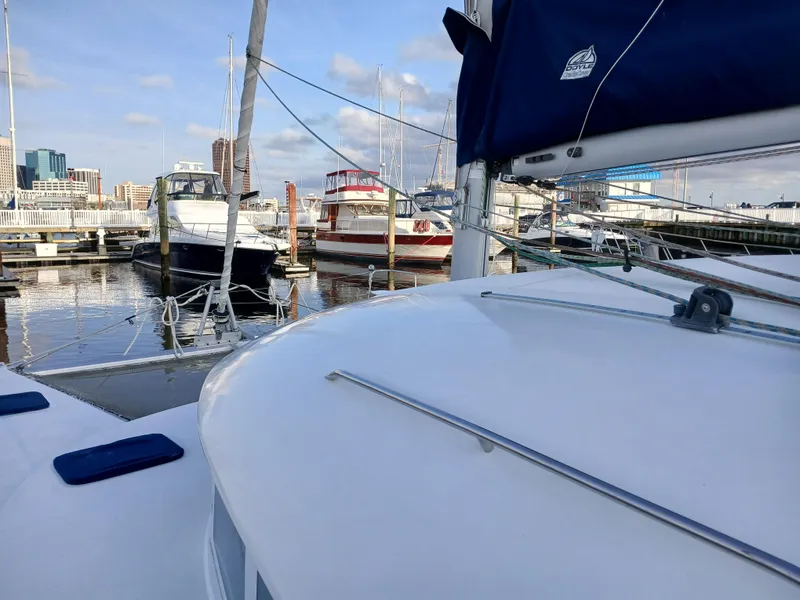 Slide: The Image of Lagoon 380 S2 catamaran docked at marina, surrounded by other boats, clear sky. - 15