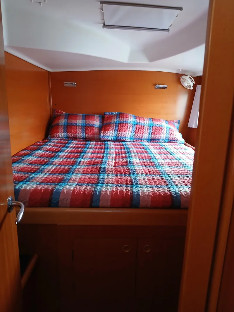 Slide: The Image of Cozy cabin bedroom in 2007 Lagoon 380 S2 with colorful plaid bedding. - 31