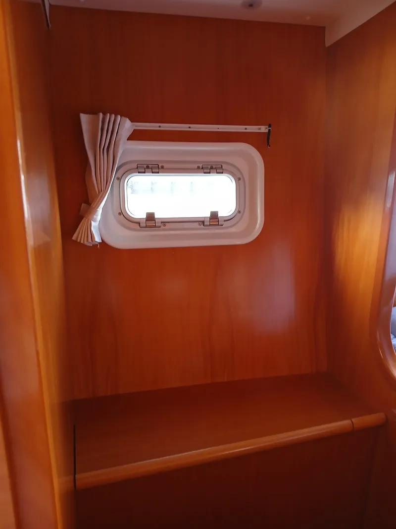 Slide: The Image of 2007 Lagoon 380 S2 interior with wooden finish and small window. - 38