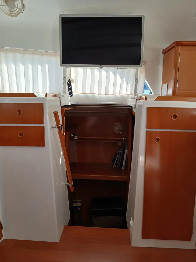 Slide: The Image of Interior of 2007 Lagoon 380 S2 catamaran with wooden cabinets and a mounted TV. - 42