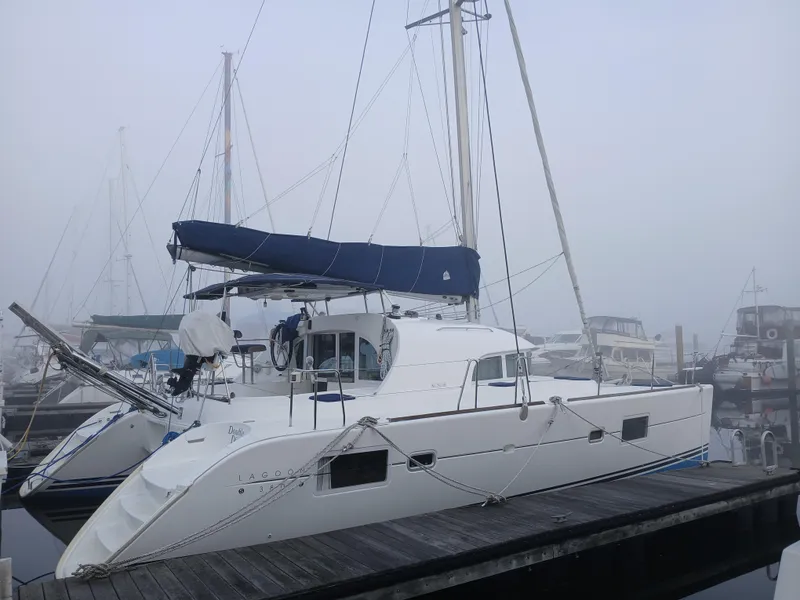Slide: The Image of 2007 Lagoon 380 S2 catamaran docked in a foggy marina. - 6