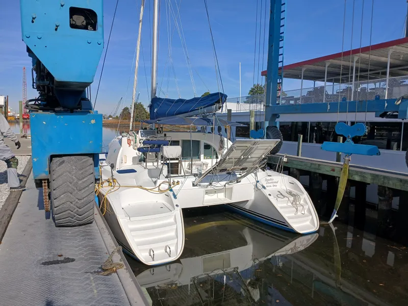 Slide: The Image of 2007 Lagoon 380 S2 catamaran docked at marina with blue crane. - 8