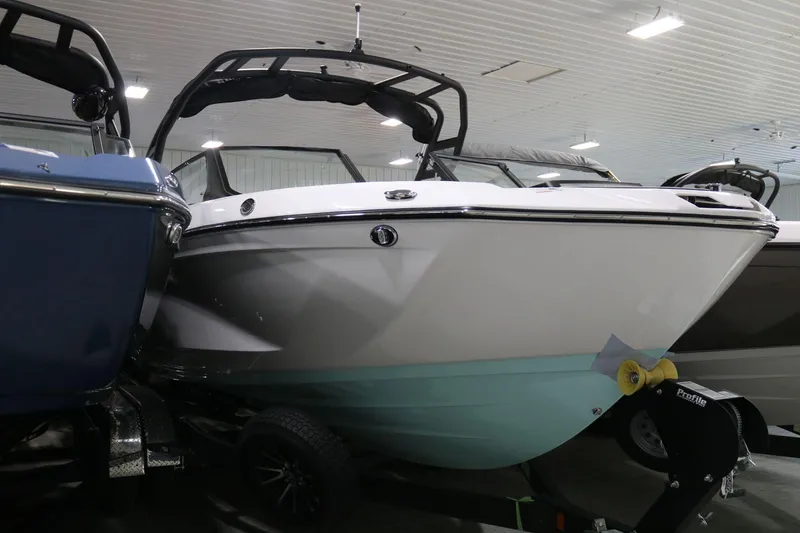 Slide: The Image of 2025 Yamaha Boats 222S in showroom, sleek design, white and teal hull. - 23