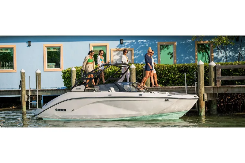 Slide: The Image of 2025 Yamaha Boats 222S docked near a colorful waterfront house. - 39