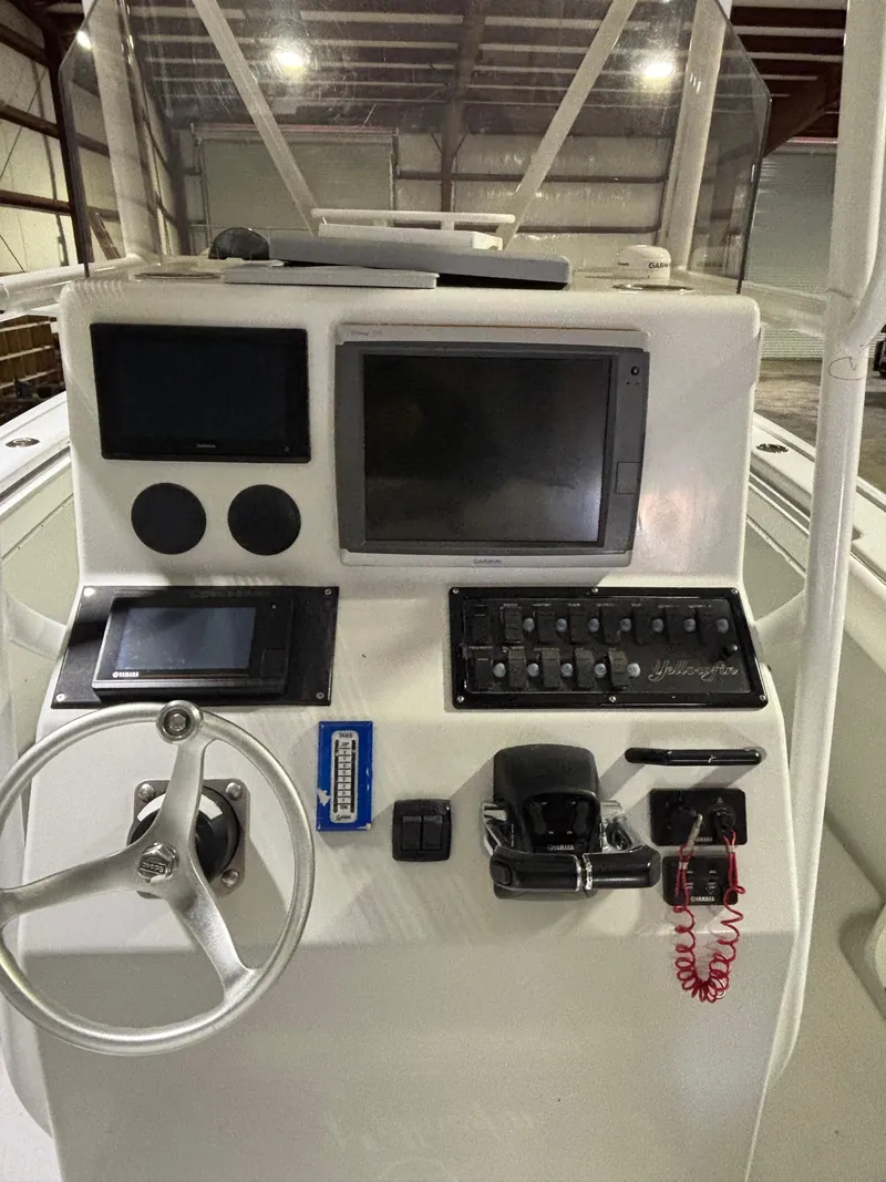 Slide: The Image of 2001 Yellowfin 31 boat dashboard with steering wheel and electronic controls. - 9