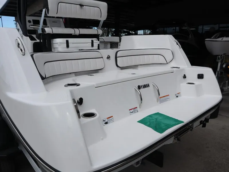 Slide: The Image of 2025 Yamaha Boats 222 FSH Sport E, rear view, white seating, sleek design. - 8