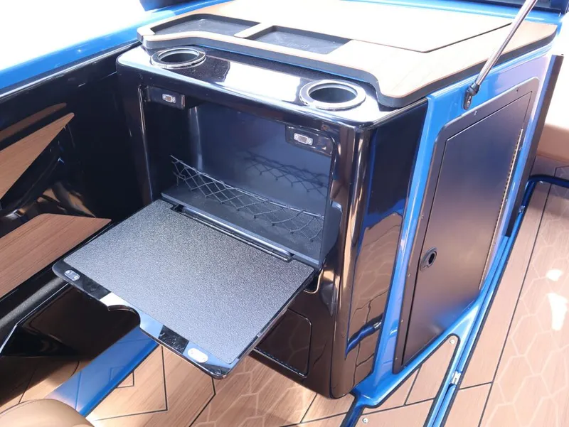 Slide: The Image of 2025 Yamaha Boats 222XD interior storage compartment with cup holders and sleek design. - 25