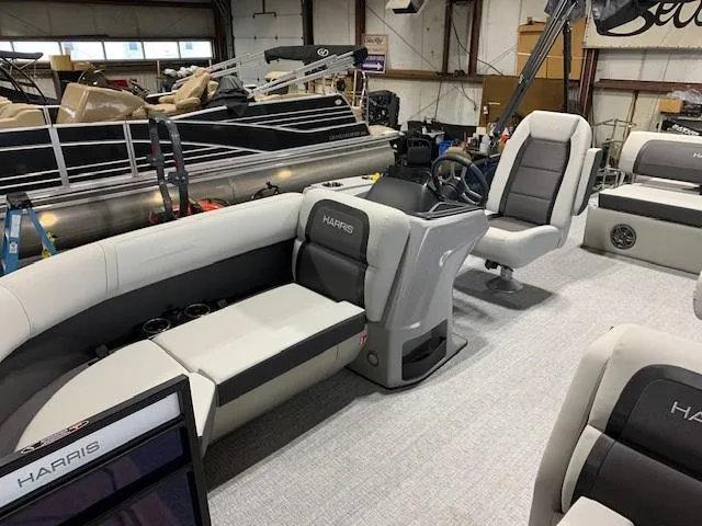 Slide: The Image of 2025 Harris Cruiser 210 interior with plush seating and modern helm in a showroom. - 4
