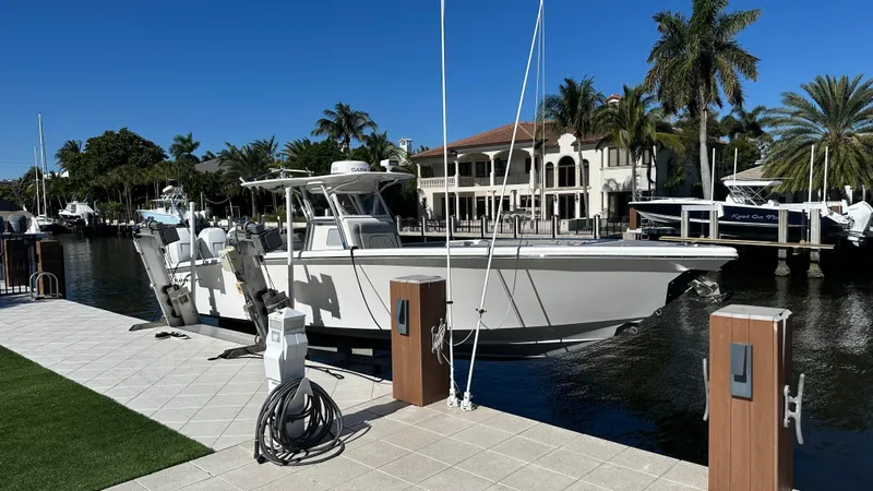 Slide: The Image of 2021 Blackwater 36 SF boat docked by waterfront homes, surrounded by palm trees. - 2