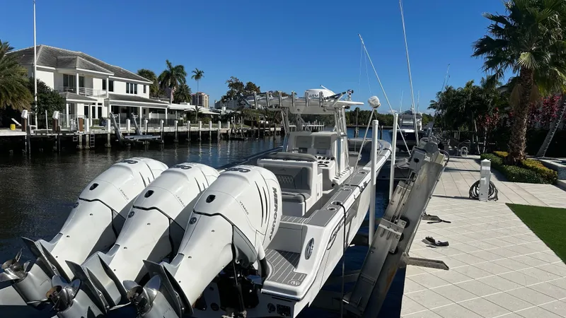Slide: The Image of 2021 Blackwater 36 SF boat docked by waterfront homes, featuring triple outboard engines. - 5