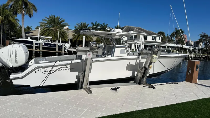 Slide: The Image of 2021 Blackwater 36 SF boat docked by waterfront homes, surrounded by palm trees. - 6