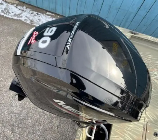 Slide: The Image of 2024 Tracker Grizzly 1860 CC with Mercury 90 outboard motor, parked on pavement. - 18