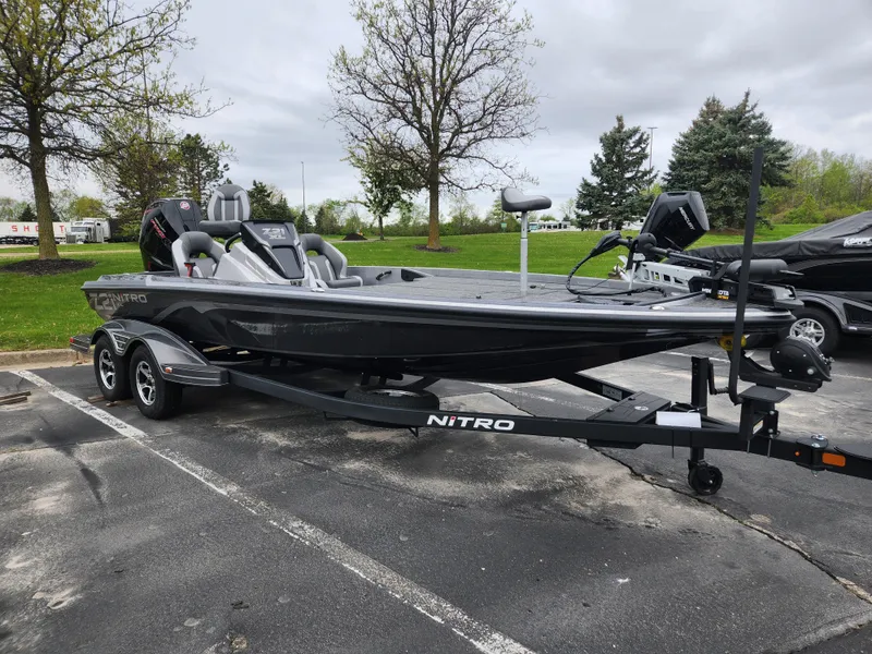 The Image of 2025 Nitro Z21 XL boat on trailer in parking lot, overcast sky. - 0