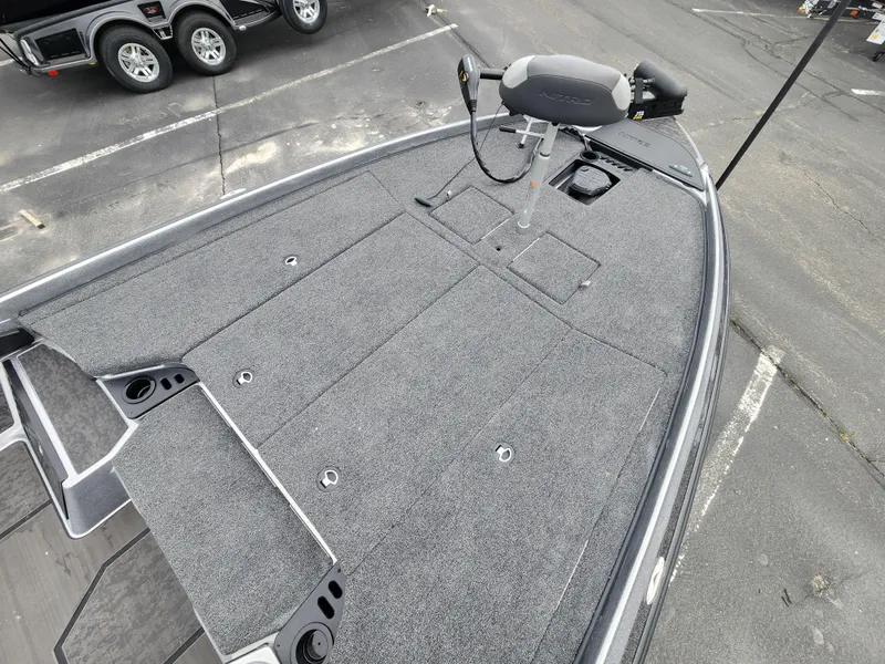 Slide: The Image of 2025 Nitro Z21 XL boat deck with trolling motor, gray carpet, and storage compartments. - 6
