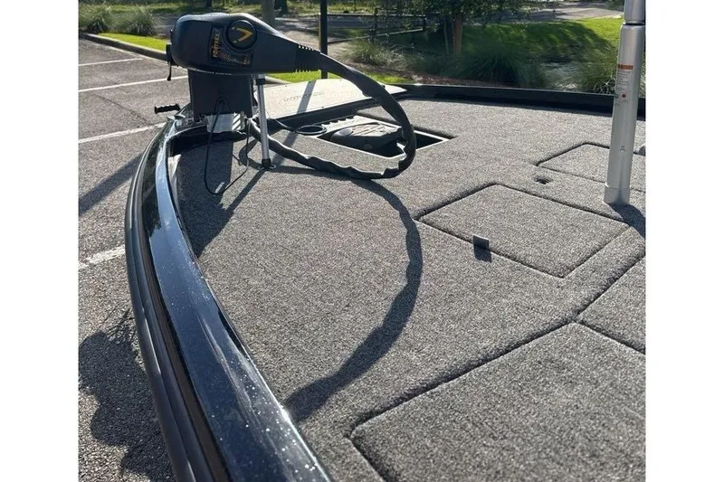 Slide: The Image of 2025 Nitro Z21 XL boat deck with trolling motor, parked outdoors on a sunny day. - 11