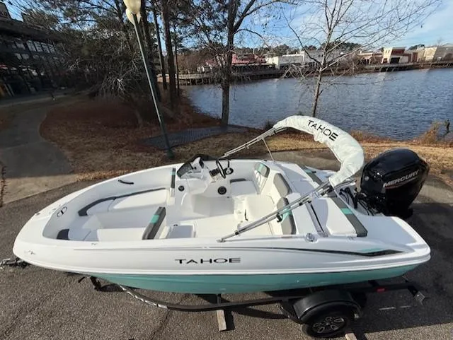 Slide: The Image of 2025 Tahoe T16 boat on trailer by a lakeside, featuring sleek design and modern outboard motor. - 40