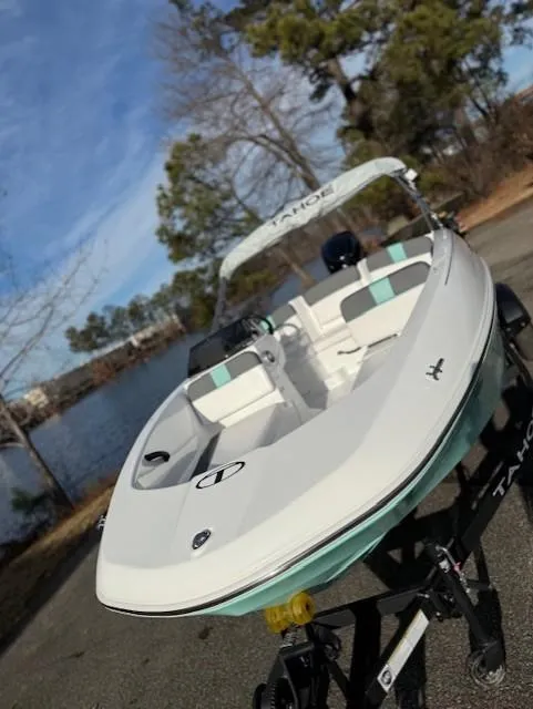 Slide: The Image of 2025 Tahoe T16 boat on trailer near a scenic lake with trees. - 43