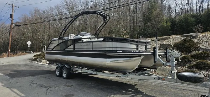 Slide: The Image of 2024 Bennington R 24 RTFBA pontoon boat on trailer, parked on roadside. - 8