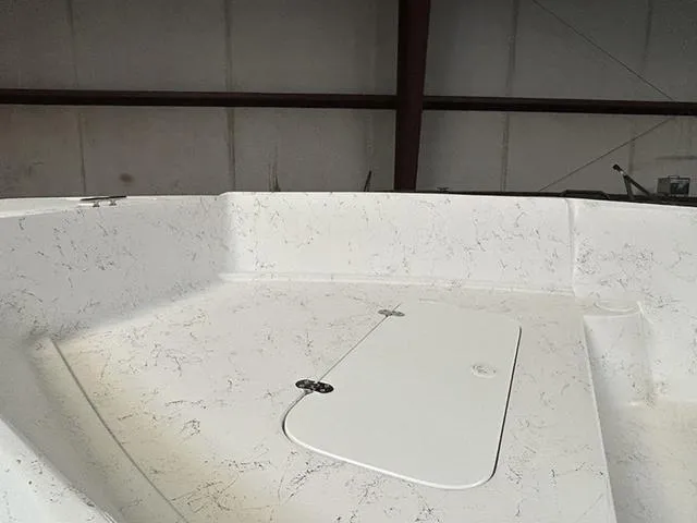 Slide: The Image of 2025 ALK2 Boats 22 CRS interior with white marbled finish in a warehouse setting. - 6