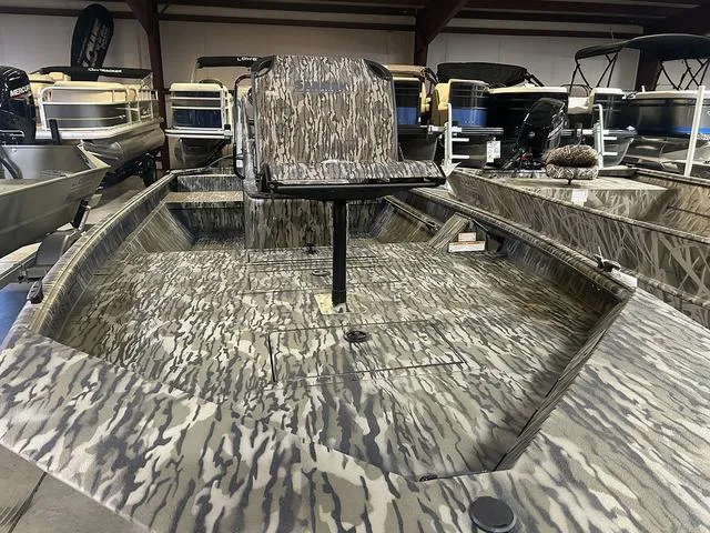 Slide: The Image of 2025 SeaArk Shadow 18 T Center Console boat with camouflage design in showroom. - 3
