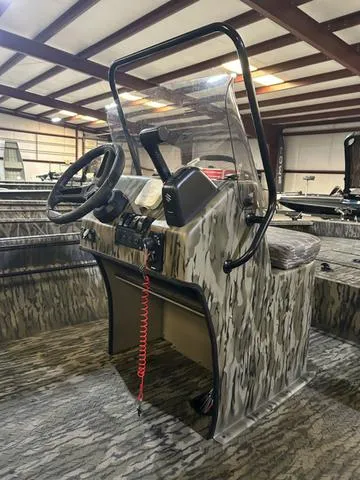 Slide: The Image of 2025 SeaArk Shadow 18 T Center Console boat with camouflage design in a warehouse. - 7