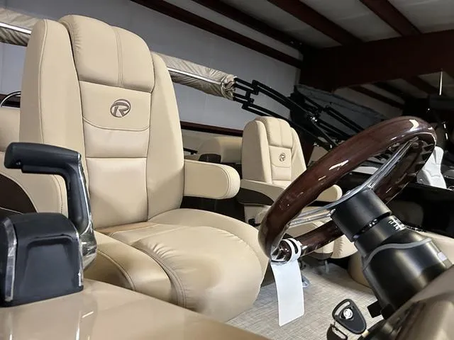 Slide: The Image of 2023 Lowe Retreat 230 RFL TLX boat interior with beige leather seats and steering wheel. - 10