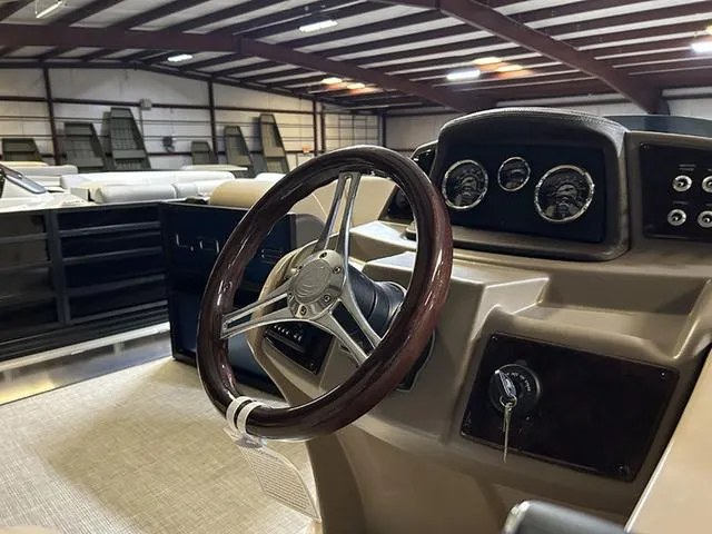 Slide: The Image of 2023 Lowe Retreat 230 RFL TLX boat interior with steering wheel and dashboard in showroom. - 11