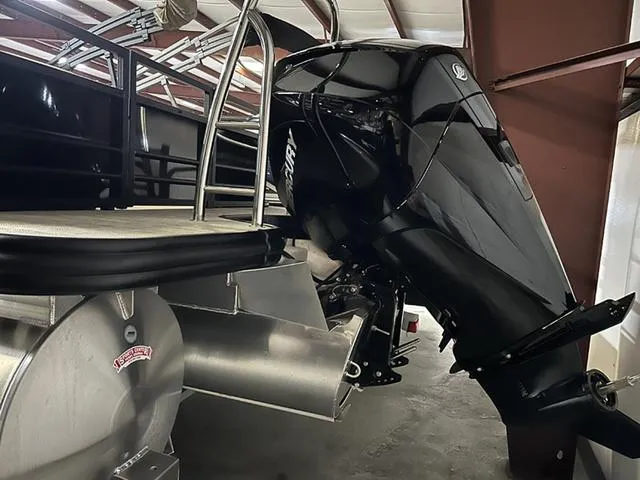 Slide: The Image of 2023 Lowe Retreat 230 RFL TLX pontoon boat with powerful outboard motor in storage. - 12