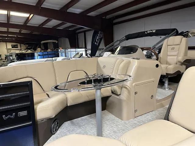 Slide: The Image of 2023 Lowe Retreat 230 RFL TLX pontoon boat interior with beige seating and table. - 3