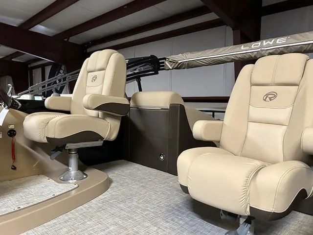 Slide: The Image of 2023 Lowe Retreat 230 RFL TLX boat interior with beige captain chairs. - 4